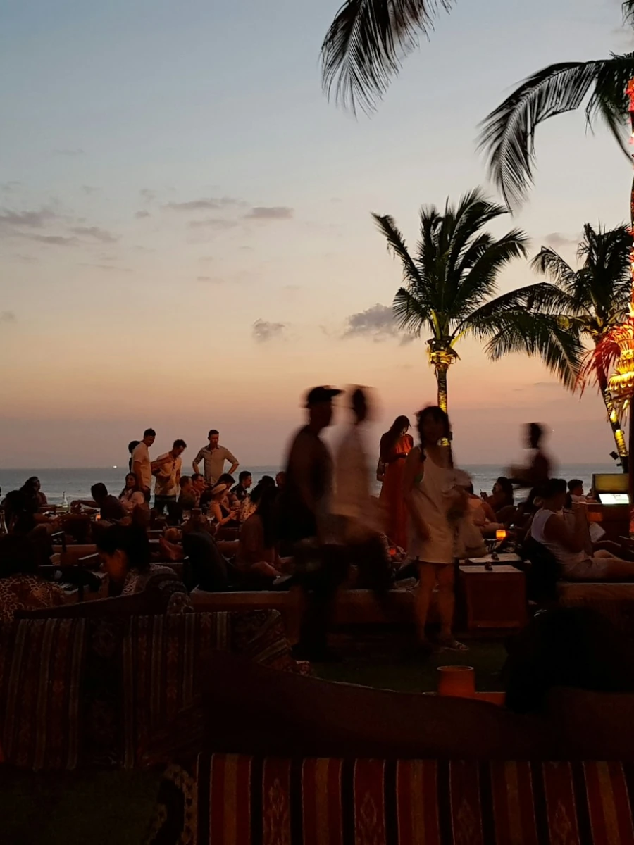 Beach club crowd at sunset on Seminyak beach